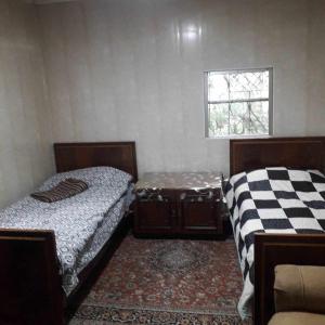 two beds sitting in a room with a window at Norik's Beach Rest Cottages in Sevan