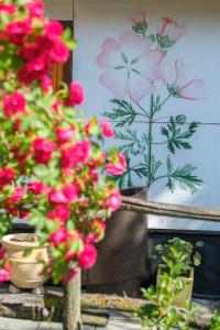a group of flowers in pots with a painting on the wall at MAZANKA ecocamping in Soshnikov