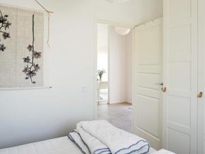 a white room with a bed and a mirror at Modern Beach Cottage in Tofta, Gotland in Gnisvärd