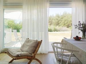 a room with a chair and a table and a window at Modern Beach Cottage in Tofta, Gotland in Gnisvärd +21 photos