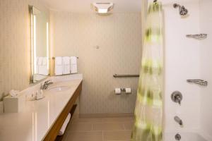 La salle de bains est pourvue d'un lavabo et d'une douche. dans l'établissement SpringHill Suites by Marriott New York LaGuardia Airport, à Queens