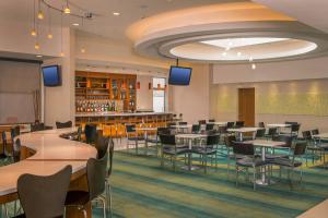 a restaurant with tables and chairs and a bar at SpringHill Suites by Marriott New York LaGuardia Airport in Queens