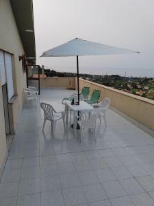 a patio with a table and chairs and an umbrella at Villa Dea in Trabia