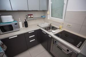 una pequeña cocina con fregadero y microondas en Apartment Bloo Suite, en Split