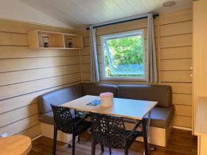 a small table and chairs in a room with a window at MORREALE MOBILE HOME (prox. Europa park/Rulantica) in Boofzheim