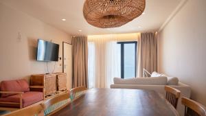 a living room with a table and a couch and a television at Azar Luxury Suites in Vlorë