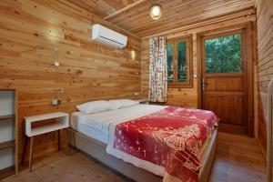 a bedroom with a bed in a wooden cabin at Chakra Beach Kabak in Faralya