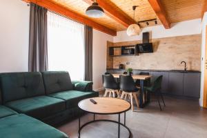 a living room with a green couch and a table at Domki Ania in Łeba
