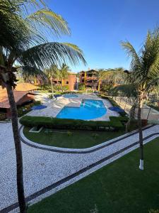 um resort com piscina e palmeiras em Happy Living Resort em Fortaleza