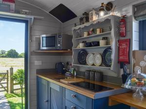 eine Küche mit einer Spüle und einer Mikrowelle in der Unterkunft Morning Mist in Strensall