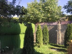 een tuin met bomen en een stenen muur bij Garden House in Jerevan