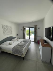 ein Schlafzimmer mit einem großen Bett und einem Fernseher in der Unterkunft VILLA Azura 5 étoiles Vue panoramique in Sainte-Maxime + 26 Fotos