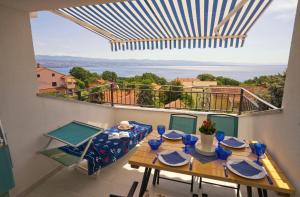 a dining room with a table and a balcony at Villa Riviera blue with seaview, pool, whirlpool, parking and boat excursions in Opric