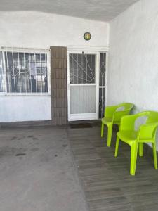 Habitación con sillas verdes, puerta y ventanas en Departamento privado con cochera y WIFI alta velocidad, en Chihuahua