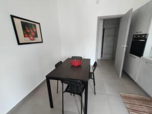 a black table and chairs in a room with a kitchen at GiErre Apartment in Termini Imerese