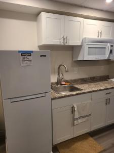 a kitchen with a white refrigerator and a sink at Bethel Joyful Home in Winnipeg