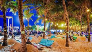 uma praia com palmeiras e uma multidão de pessoas em Happy Living Resort em Fortaleza