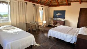 a hotel room with two beds and a table and a window at Bungalows Las Palmas Cabo Pulmo in Cabo Pulmo