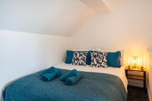 1 dormitorio con 1 cama grande con almohadas azules en Medium long term stays welcome, en Heeley