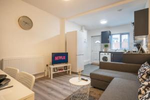 a living room with a couch and a kitchen at Medium long term stays welcome in Heeley