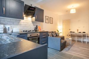 a kitchen and living room with a couch at Medium long term stays welcome in Heeley