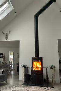 a fireplace in a living room with a stove at Camden House luxury home near Ben Nevis Scotland Highlands in Fort William