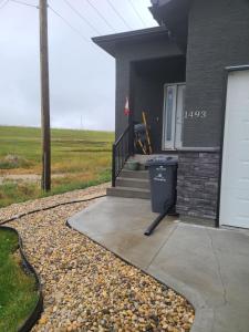 un cubo de basura sentado fuera de una casa en Bethel Joyful Home en Winnipeg