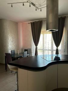 eine Küche mit einer schwarzen Arbeitsplatte und einem Tisch in der Unterkunft Kennedy Apartment in Quattromiglio
