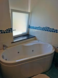 a bath tub in a bathroom with a window at Hotel Da Maria in Ischia
