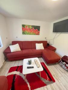 sala de estar con sofá rojo y mesa en Extra House en Balatonvilágos