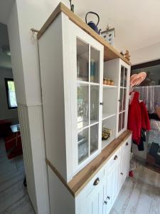 un gran armario blanco con puertas de cristal en una habitación en Extra House en Balatonvilágos