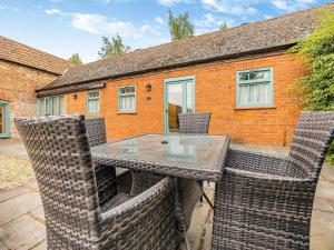 a dining table with chairs and a brick building at The Stables - Uk44515 in North Thoresby