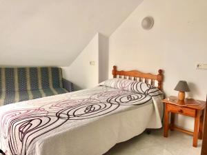 1 dormitorio con 1 cama y 1 mesa con lámpara en Pensión Rey en Isla de Arosa