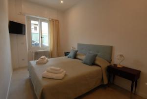 1 dormitorio con 1 cama con 2 toallas en Le Case di Elena - Gignese, en Gignese