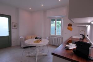 sala de estar con mesa blanca y cocina en Le Case di Elena - Gignese, en Gignese
