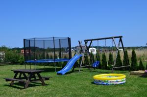 a playground with a slide and a picnic table at Dom Gościnny "Berberys" in Rewal