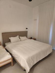 een slaapkamer met een groot bed met witte lakens bij סוויטה פרטית ברמת צבי in Temarah