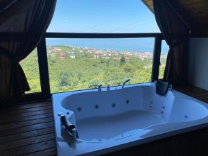 a bath tub in a room with a large window at VİLLA DENİZ , KiRAZ in Trabzon +43 photos
