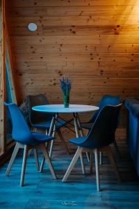 una mesa y sillas en una habitación con una pared de madera en cabana KARMA en Bistra