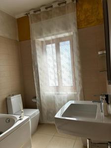 ein Badezimmer mit einer Badewanne, einem WC und einem Waschbecken in der Unterkunft Kennedy Apartment in Quattromiglio