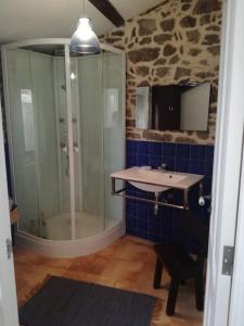bagno con doccia in vetro e lavandino di Casa rural de piedra en una aldea tranquila de Zas 