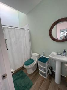 een badkamer met een toilet, een wastafel en een spiegel bij Casa “PLAYA DORADA” in Mazatlán