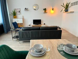 a living room with a black couch and a table at Vilvoorde city center in Vilvoorde