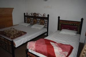 two beds sitting next to each other in a room at Siwakhat Huts in Shoghot