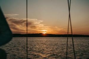 a sunset seen from a boat on a body of water at Vayu in Nida