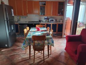 eine Küche mit einem Tisch mit Stühlen und einem Kühlschrank in der Unterkunft Ndiscialamu Casa Vacanze in Palmi