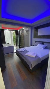 a bedroom with a large bed with a blue ceiling at BORDO SUİTE HOTEL in Trabzon