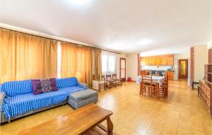 uma sala de estar com um sofá azul e uma cozinha em Gorgeous Home In Reus With Kitchenette em Reus