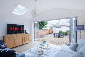a living room with a couch and a tv at Beautiful House - Sleeps 8 - Close to City Centre with Free Parking, Fast Wifi and Smart TV with Virgin TV and Netflix by Yoko Property in Northampton