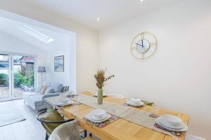 comedor con mesa y sofá en 4 Bedroom House - Sleeps 8 - Close to City Centre with Free Parking, Fast Wifi and Smart TV with Virgin TV and Netflix by Yoko Property en Northampton